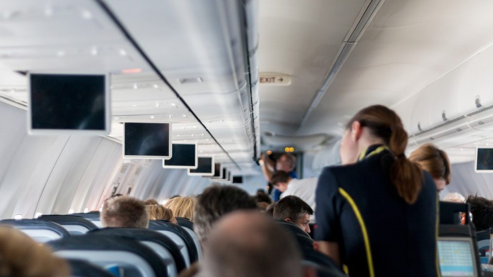 Une hôtesse de l'air s'occupe des passagers dans un avion