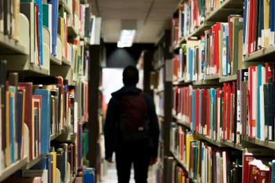 jeune homme de dos dans une bibliothèque