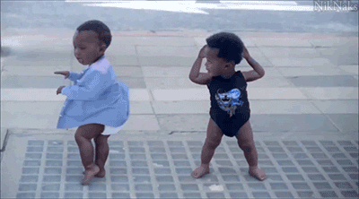 Deux bébés dansent dans la rue.
